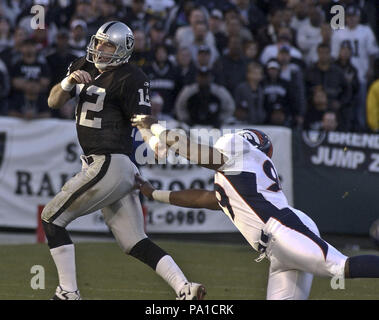 Oakland, Kalifornien, USA. 22 Dez, 2002. Denver Broncos defensiver Montae Reagor (99) verpasst, Oakland Raiders Quarterback Rich Gannon (12) am Sonntag, 22 Dezember, 2002 in Oakland, Kalifornien. Die Räuber besiegt die Broncos 28-16. Credit: Al Golub/ZUMA Draht/Alamy leben Nachrichten Stockfoto