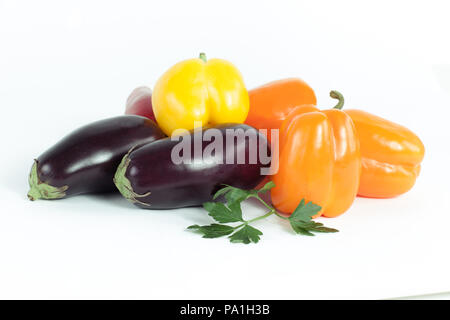 Paprika, Auberginen und Zweige Petersilie auf einem weißen backgroun Stockfoto