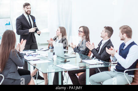 Business Team applaudieren dem Leiter Finanzen bei der Vorstellung des neuen Projektes am Arbeitsplatz Stockfoto