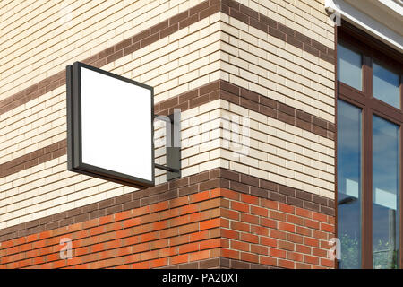 Leeres quadratisches Singboard an der Ziegelwand Stockfoto