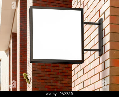 Leeres quadratisches Singboard an der Ziegelwand Stockfoto