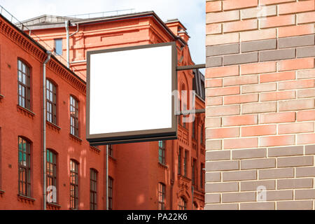 Leeres quadratisches Singboard an der Ziegelwand Stockfoto