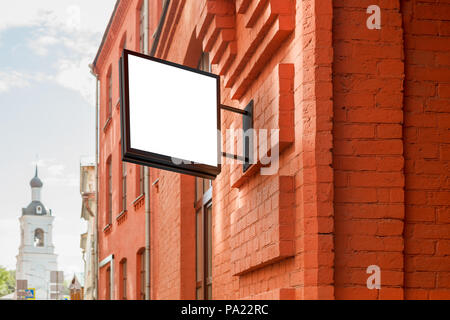 Leeres quadratisches Singboard an der Ziegelwand Stockfoto
