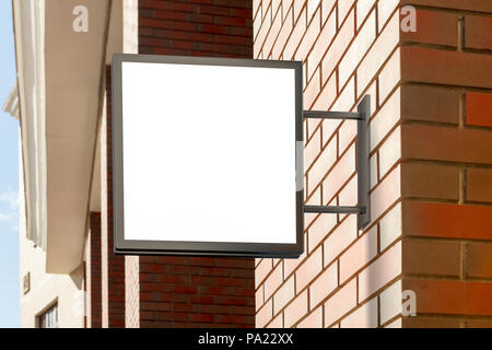 Leeres quadratisches Singboard an der Ziegelwand Stockfoto
