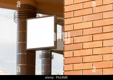 Leeres quadratisches Singboard an der Ziegelwand Stockfoto