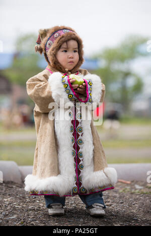 Junge Kind isst einen Apfel in Okhotsk Stockfoto