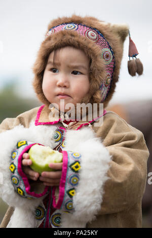 Junge Kind isst einen Apfel in Okhotsk Stockfoto