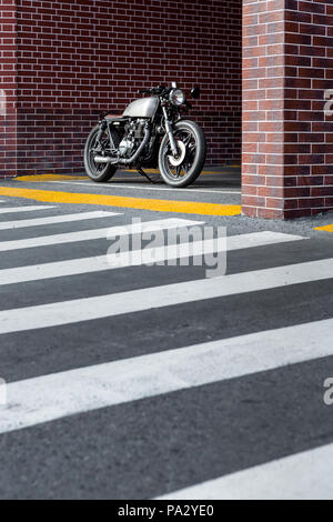 Caferacer Motorrad Parkplatz in der Nähe der Mauer der industriellen Gebäude. Alles ist bereit für Spaß nach einem harten Tag im Büro. Geschäftsmann Stadt Hüften Stockfoto