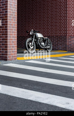 Altes Motorrad Parkplatz in der Nähe der Mauer der industriellen Gebäude. Alles ist bereit für Spaß nach einem harten Tag im Büro. Geschäftsmann Stadt hipster Ho Stockfoto