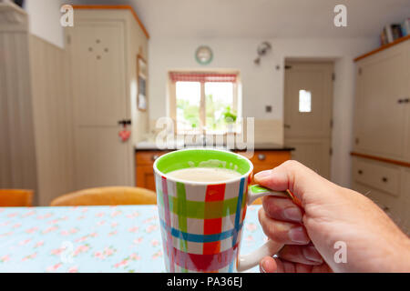 Eine Person, die eine Tasse voll latte Sicht verschieben der Kaffee auf die Personen Mund in Landhaus am Morgen Stockfoto