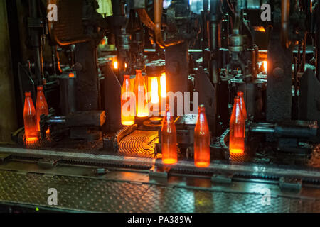 Automatisierten Fertigungslinie für die Herstellung von Glasbehältern. Die Flaschen werden auf einem beweglichen Förderband setzen Stockfoto