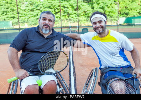 Paar deaktiviert Tennis Spieler gegenseitig im Rahmen der Net umarmt nach dem Turnier im Freien Stockfoto