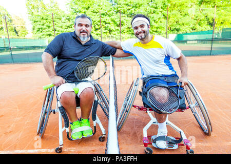 Paar deaktiviert Tennis Spieler gegenseitig im Rahmen der Net umarmt nach dem Turnier im Freien Stockfoto