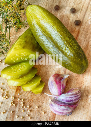 Gurken, Knoblauch, Dill und Senf auf einem Holzbrett Stockfoto