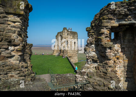 Ruinen der Burg Feuerstein neben dem Dee Estuary in Nord Wales, Großbritannien. Touristen um die Türme an einem sonnigen Frühlingstag. Stockfoto