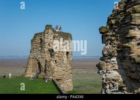 Ruinen der Burg Feuerstein neben dem Dee Estuary in Nord Wales, Großbritannien. Touristen um die Türme an einem sonnigen Frühlingstag. Stockfoto