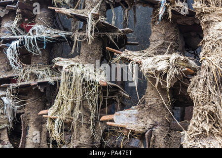 Landwirtschaftliche Maschinen auf dem Bauernhof. Der Mechanismus auf dem Anhänger - Vertrieb von Düngemitteln aus Kuhmist und Stroh. Nach der Arbeit auf dem Feld. Close-up. Stockfoto