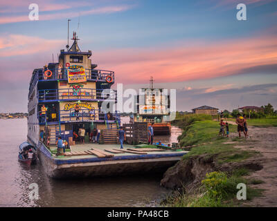 Santa Rosa, Peru - Mar 24, 2018: Sonnenuntergang über dem Amazonas und die Ladung Boot im Hafen warten. Stockfoto