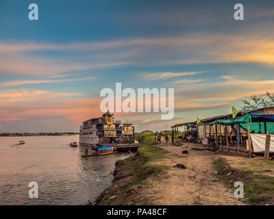 Santa Rosa, Peru - Mar 24, 2018: Sonnenuntergang über dem Amazonas und die Ladung Boot im Hafen warten. Stockfoto
