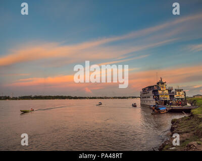 Santa Rosa, Peru - Mar 24, 2018: Sonnenuntergang über dem Amazonas und die Ladung Boot im Hafen warten. Stockfoto