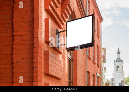 Leeres Ladenschild an der Ziegelwand. Quadratische Beschilderung. Stockfoto