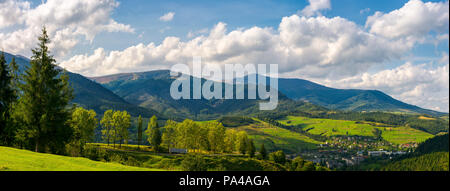 Panorama der bergigen Stadtgebiet. schöne Landschaft Landschaft im frühen Herbst Bäume entlang der Straße den Hügel hinunter. Dorf unten im Tal und c Stockfoto