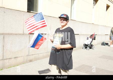 Juli 16th, 2018, Helsinki, Finnland. Eine Person auf der Straße mit den Amerikanischen und Russischen Fahnen. Stockfoto