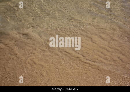 Sand in den Wellen des Chicago Montrose Avenue Dog Beach zu einer lustigen Sommertag in Michigan See treiben. Stockfoto