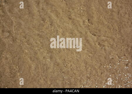 Sand in den Wellen des Chicago Montrose Avenue Dog Beach zu einer lustigen Sommertag in Michigan See treiben. Stockfoto