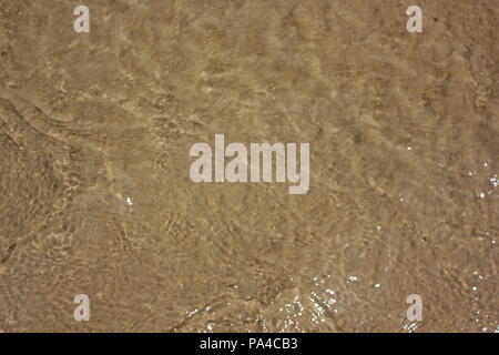 Sand in den Wellen des Chicago Montrose Avenue Dog Beach zu einer lustigen Sommertag in Michigan See treiben. Stockfoto