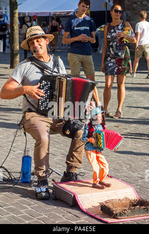 Busker/Street Performer mit Puppe spielen Akkordeon Während der Gentse Feesten/Gent Festival, Sommerfeste in Gent, Flandern, Belgien Stockfoto