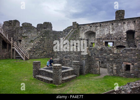 Besucher, die an der gut innen Dunstaffnage Castle durch die MacDougall Herren von Lorn in Argyll und Bute gebaut, westlichen schottischen Highlands, Schottland Stockfoto