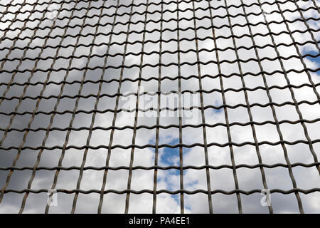 Alte metall gitter gegen den blauen Himmel und dunklen Wolken am Himmel, Nahaufnahme Stockfoto