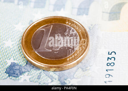 Ein Euro liegt auf einer Europäischen Banknote von zehn Euro, Nahaufnahme, auf einer Münze, geringe Tiefenschärfe Fokus Stockfoto