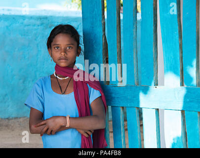 Schönen indischen Mädchen Porträt trägt blaue oben gegen eine blaue Wand in Kanha Village in der Nähe der Kanha Nationalpark, in Indien Stockfoto