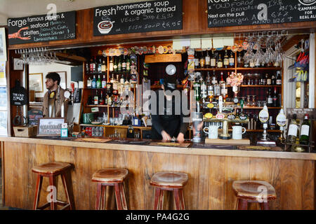 Die Bar und der Barkeeper an der Alten Schmiede, der am weitesten entfernten Pub im Mutterland Großbritannien, in der Stadt von Inverie, Halbinsel Knoydart, Schottland, Großbritannien. Stockfoto