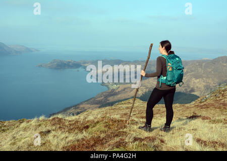 Eine weibliche Wanderer mit Stock auf einem Berg Aussichtspunkt auf sgurr Coire Choinnichean auf der Halbinsel Knoydart, Scottish Highlands, Schottland, Großbritannien. Stockfoto