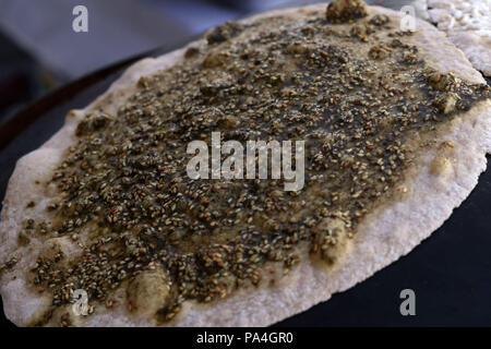 Mankousheh, ein Libanesisches Fladenbrot mit Thymian, Öl, Gewürze und Käse auf einem saj Backofen gesehen gemacht Stockfoto