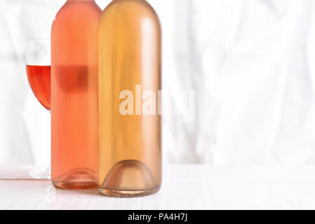 Wein noch Leben: High key Weinflaschen auf weißem Holz Tisch vor einem Fenster. Stockfoto