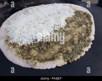 Mankousheh, ein Libanesisches Fladenbrot mit Thymian, Öl, Gewürze und Käse auf einem saj Backofen gesehen gemacht Stockfoto