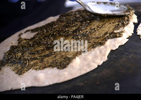 Mankousheh, ein Libanesisches Fladenbrot mit Thymian, Öl, Gewürze und Käse auf einem saj Backofen gesehen gemacht Stockfoto