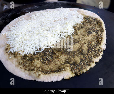 Mankousheh, ein Libanesisches Fladenbrot mit Thymian, Öl, Gewürze und Käse auf einem saj Backofen gesehen gemacht Stockfoto