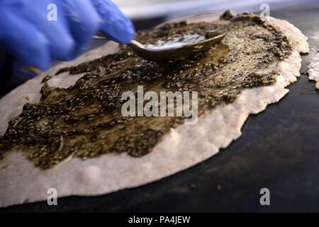 Mankousheh, ein Libanesisches Fladenbrot mit Thymian, Öl, Gewürze und Käse auf einem saj Backofen gesehen gemacht Stockfoto