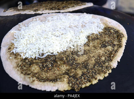 Mankousheh, ein Libanesisches Fladenbrot mit Thymian, Öl, Gewürze und Käse auf einem saj Backofen gesehen gemacht Stockfoto