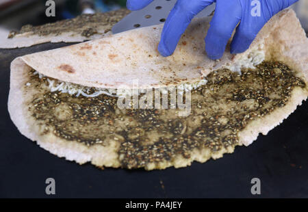 Mankousheh, ein Libanesisches Fladenbrot mit Thymian, Öl, Gewürze und Käse auf einem saj Backofen gesehen gemacht Stockfoto