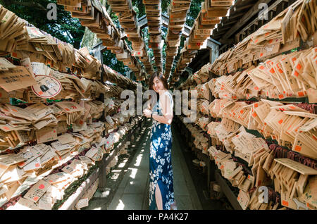 Portrait von schöne asiatische Girl posiert im Tunnel von Ema-Holz- gebet Platten an Kawagoe Hikawa Schrein. Der Schrein ist bekannt für Spiel machen Stockfoto