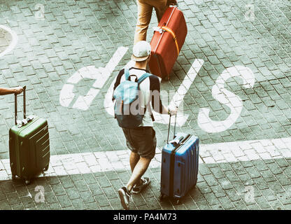 Ansicht von oben der Touristen wheeling Koffer über Stop-Schild auf die Straße gemalt. Konzept anti touristische Image für Städte wie Barcelona, Venedig ... Stockfoto