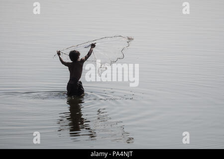 Ein Fischer in der Taung Tha Mann See wirft einen Fisch net im Wasser, Myanmar Stockfoto