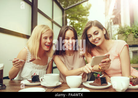 Zwei Freundinnen verbringen die Zeit zusammen trinken Kaffee im Cafe, das Frühstück und Dessert. Stockfoto