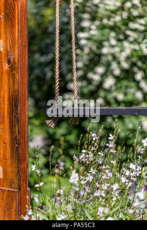 Holz- Schwingen im Sommer Garten Stockfoto